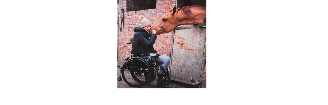 a photo of Sarra, a young woman with brown hair in a wheelchair giving a brown horse a nuzzle on the muzzle