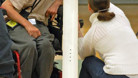 man placing boccia ball onto ramp with his chin 