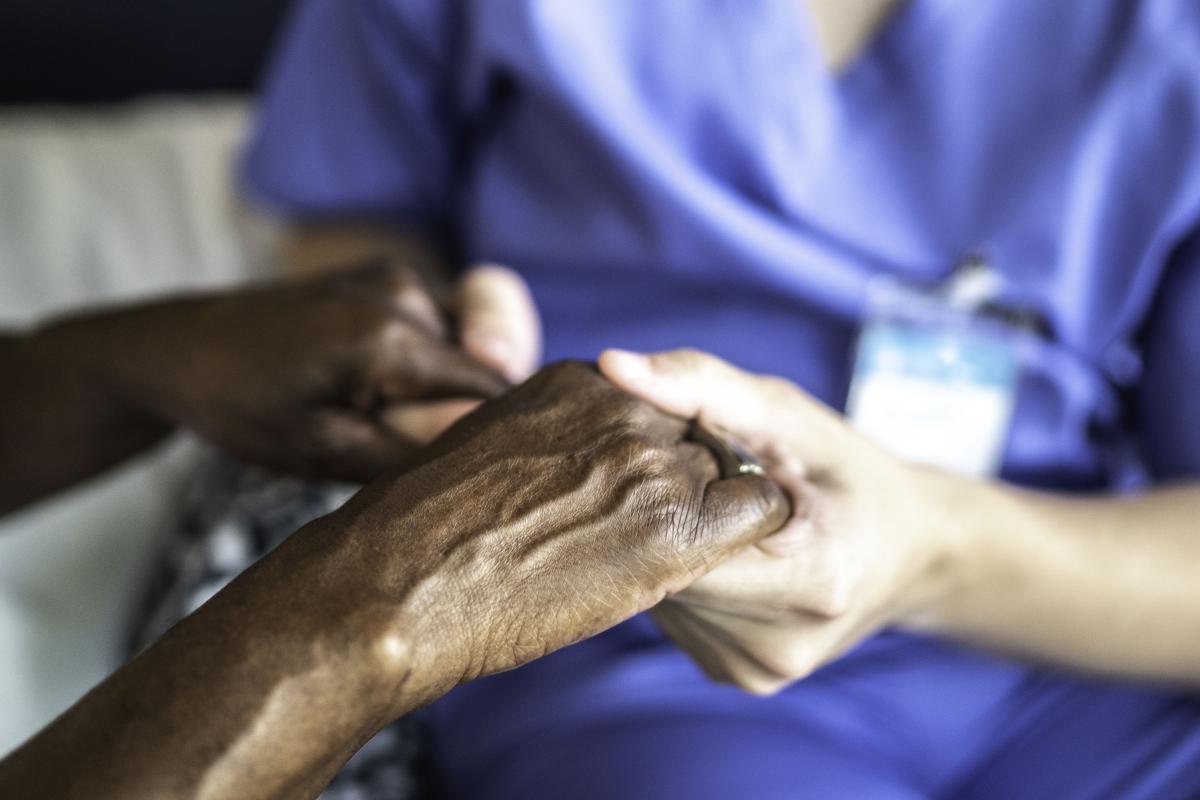 Nurse holds hands of patient