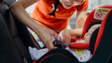 Mom buckling child into car seat