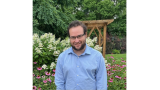 Scott Roiter stands in front of foliage